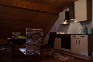 kuchnia ze stołem i krzesłami w pokoju w obiekcie Appartement Haus Kruschitz II w mieście Ludmannsdorf