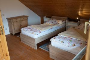 sypialnia z dwoma łóżkami i drewnianym sufitem w obiekcie Appartement Haus Kruschitz II w mieście Ludmannsdorf