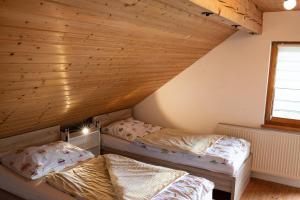 dwa łóżka w pokoju z drewnianym sufitem w obiekcie Appartement Haus Kruschitz II w mieście Ludmannsdorf