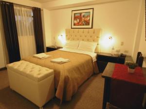 una habitación de hotel con una cama grande y una silla en Hotel Montecristo Cusco, en Cusco