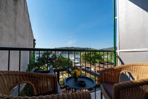 einen Balkon mit 2 Stühlen und einem Tisch mit Aussicht in der Unterkunft Hotel Dalmacija in Vela Luka