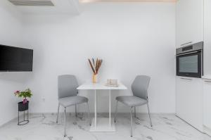 kuchnia z białym stołem i 2 krzesłami w obiekcie Apartman Knezevic A w Fažanie