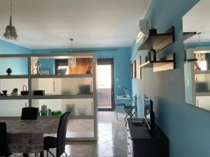 a dining room with a table and a blue wall at Esmeralda Apartment in Palermo