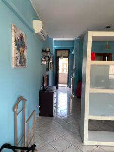 Habitación con paredes azules y pasillo con mesa. en Esmeralda Apartment, en Palermo