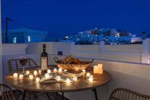 a table with a bottle of wine and a basket of fruit at Flèria Seaview Suites in Naxos Chora
