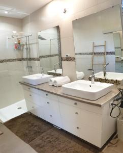 菲雅克的住宿－les Box，一间带两个盥洗盆和大镜子的浴室