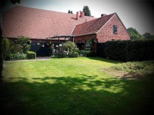 a house with a large yard with a house at Twisterhof, appartement Anna, in Sustrum +9 photos