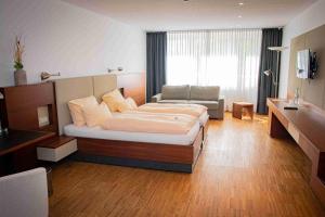 pokój hotelowy z łóżkiem i kanapą w obiekcie Gästehaus an der Oase w mieście Versmold