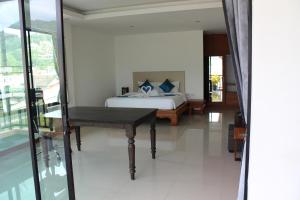 ein Schlafzimmer mit einem Bett und einem Schreibtisch. in der Unterkunft B Happy Resort - SHA ExtraPlus in Kamala Beach