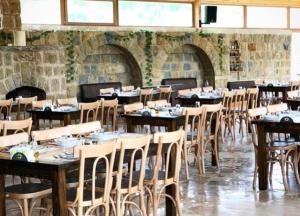 uma sala de jantar com mesas e cadeiras de madeira em Nassamat Boutique Hotel em Al Bārūk