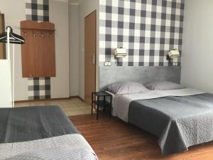 a bedroom with two beds and a checkerboard wall at OW Delta in Rewal +63 photos