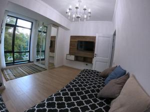a bedroom with a black and white bed and a chandelier at Радуга Иссык-Куль in Chon-Sary-Oy