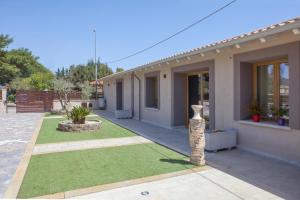 a house with a yard with green grass at Relais Borgo Camisa in Castiadas