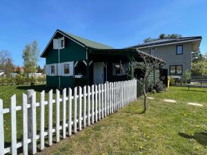 ein weißer Gartenzaun vor einem Haus in der Unterkunft Domek letniskowy in Świnoujście