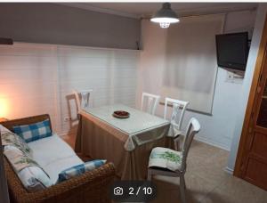 - une salle à manger avec une table, des chaises et une télévision dans l'établissement CASA ENROCADA, à Setenil de las Bodegas