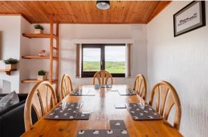 a dining room with a wooden table and chairs at Lodge Cabin with Fabulous Views - Farm Holiday in Stranraer