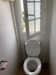 um WC branco numa casa de banho com uma janela em le Petit futé 112 em Biville-sur-Mer
