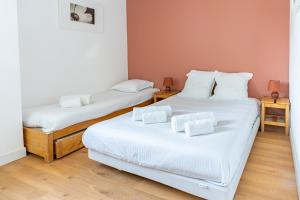 two beds with white sheets in a room at TERRE MARINE - Bel appartement avec terrasse vue mer in Cassis