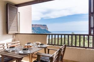 een tafel op een balkon met uitzicht op de oceaan bij TERRE MARINE - Bel appartement avec terrasse vue mer in Cassis
