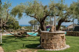 a garden with a tree and a swing at I Ginepri Hotel in Cala Gonone