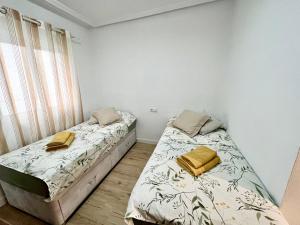 sypialnia z 2 łóżkami i oknem w obiekcie Sunny Escape in El Campello w mieście El Campello