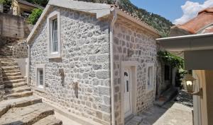 a stone house with white doors and stairs on a building at Casa Vecchia in Kotor