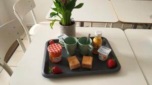 ein Tablett mit Speisen, Getränken und Erdbeeren auf dem Tisch in der Unterkunft Chambre Aliénor d'Aquitaine in Bordeaux