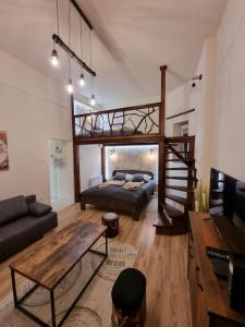 uma sala de estar com uma cama alta e um sofá em Vintage Apartman in city center em Miskolc
