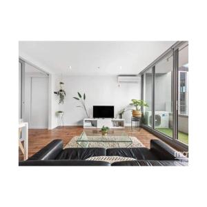 a living room with a couch and a tv at Lovely apartment in Melbourne