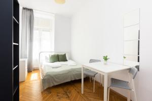 a white bedroom with a bed and a table at Rooms Nearto Main Square in Krakow