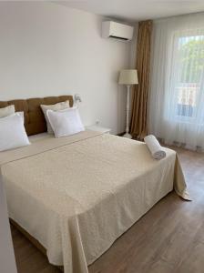 een slaapkamer met een groot bed en een groot raam bij Hotel AVENUE in Ravda
