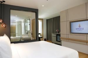 Un pat sau paturi într-o cameră la Miracle Grand Convention Hotel