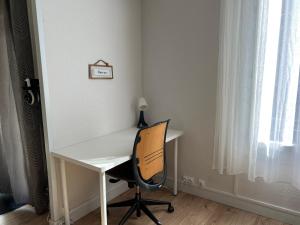 un bureau blanc avec une chaise à côté d'une fenêtre dans l'établissement Spacieux Marx Dormoy avec parking gratuit C, à Clermont-Ferrand