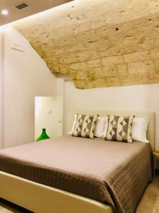 een slaapkamer met een bed en een stenen plafond bij Arvian B&B in Bari