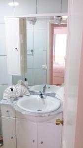 プラヤ・デル・クーラにあるApartamento Alegriaのバスルーム(白い洗面台、鏡付)