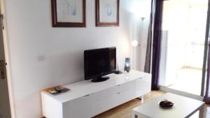 a living room with a white entertainment center with a flat screen tv at Apartamento Alegria in Playa del Cura
