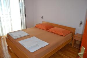 ein Schlafzimmer mit einem Bett mit orangefarbenen Kissen darauf in der Unterkunft Tivat Apartments in Tivat