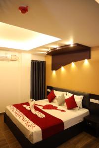 a bedroom with a bed with red and white pillows at Igloo Heritage Resorts in Idukki