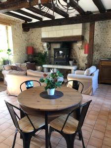 a living room with a table with chairs and a couch at Cottage du vigneron in Vernou-sur-Brenne