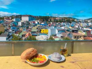 a table with two plates of food and a glass of beer at Dalat Backpacker's Alley Hostel in Da Lat
