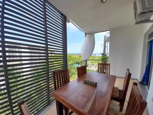 a dining room with a wooden table and a large window at Aqua Resort in Diani Beach