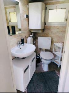 a bathroom with a white sink and a toilet at Bungalow "Strandblick" in Göhren +13 photos
