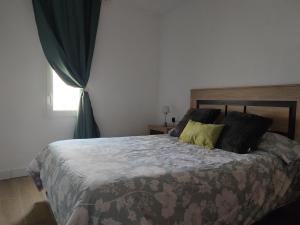 sypialnia z dużym łóżkiem i zielonymi poduszkami w obiekcie Encantadora Casa con Patio w mieście Ronda