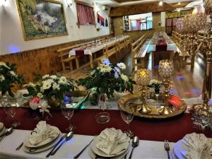 a dining room with a long table with flowers on it at Apatments Radoja - Pliva in Šipovo