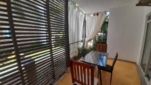 a room with a table and a large window with blinds at Aqua Resort in Diani Beach