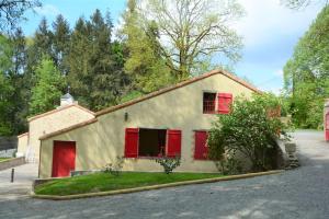 mały dom z czerwonymi okiennicami na ulicy w obiekcie Gite La Minoterie - Piscine & spa 