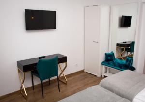 a room with a desk and a tv on a wall at Pensiunea Delia Timișoara in Timişoara
