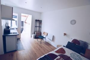 a bedroom with a bed and a kitchen with a counter at Studios Lsquare-Residence in Châtellerault