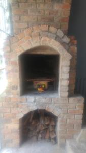 un horno de ladrillo con un montón de madera. en Four Seasons Self-Catering Guest House en Graskop