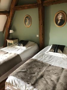 two beds in a room with green walls at Cottage du vigneron in Vernou-sur-Brenne